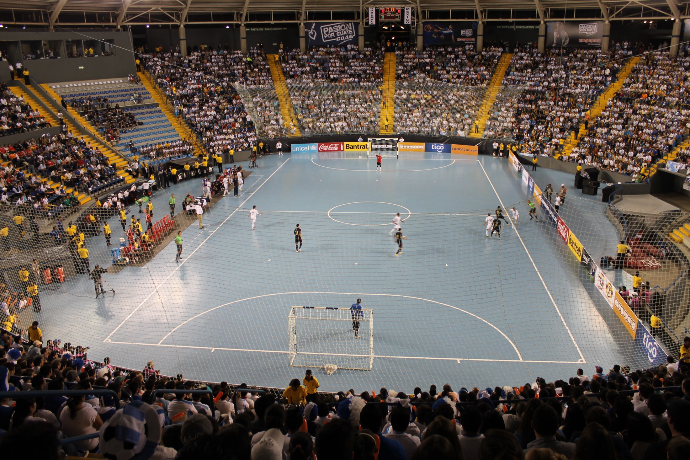 A futsal match in a packed indoor arena
