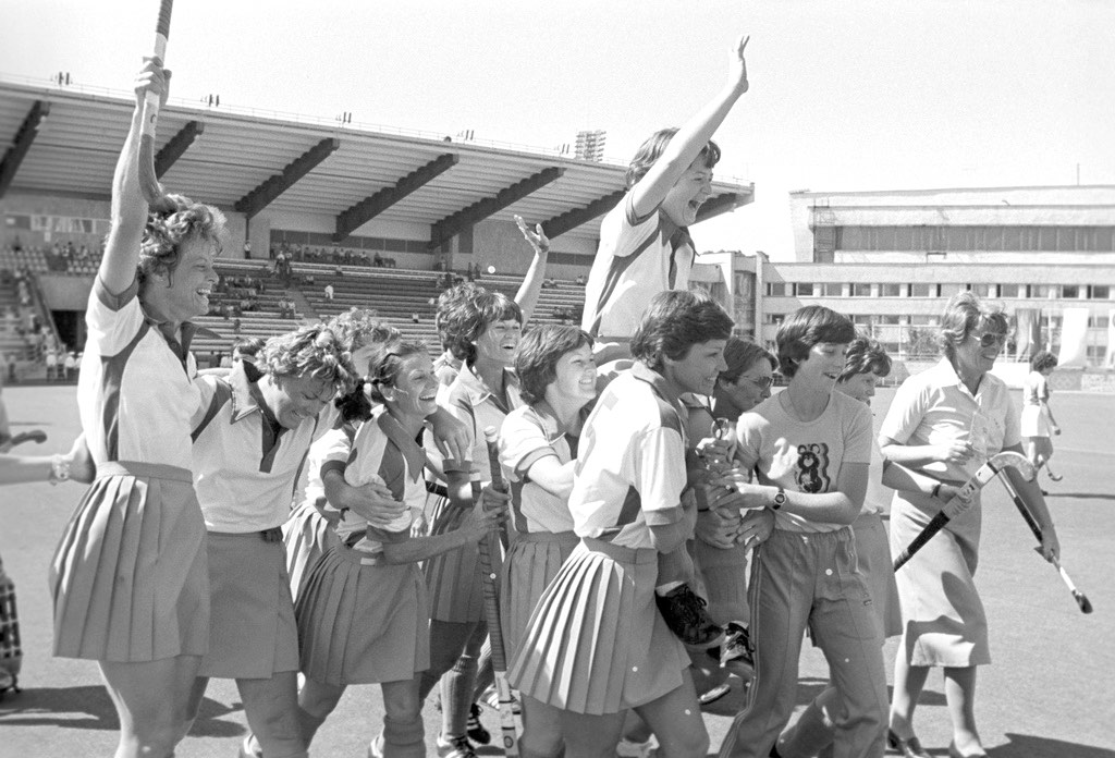 A women’s field hockey team celebrating together after a win