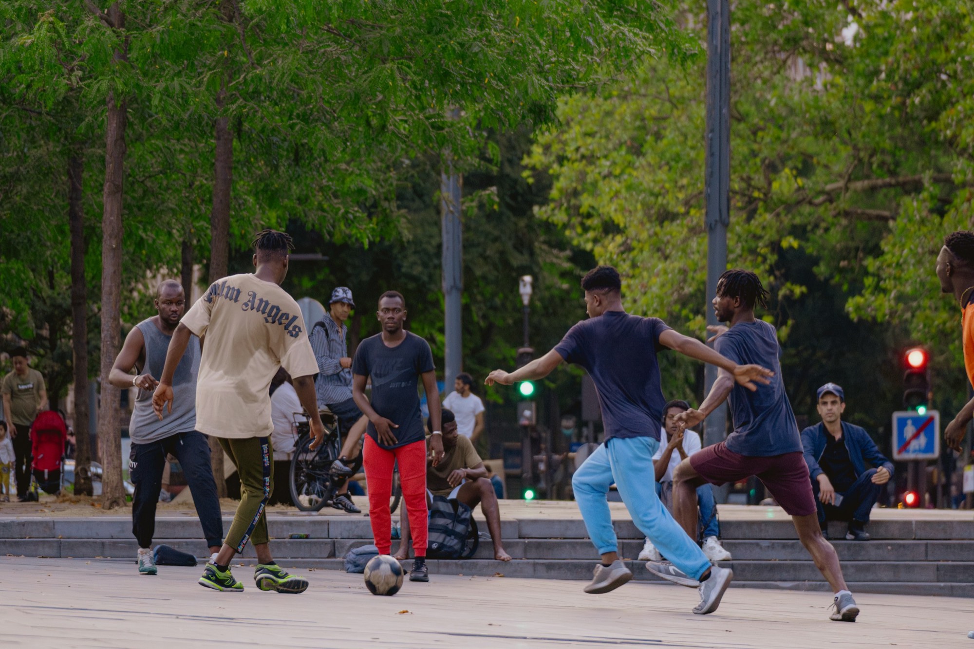 A kickabout in a city park, everyone still in the clothes they arrived in