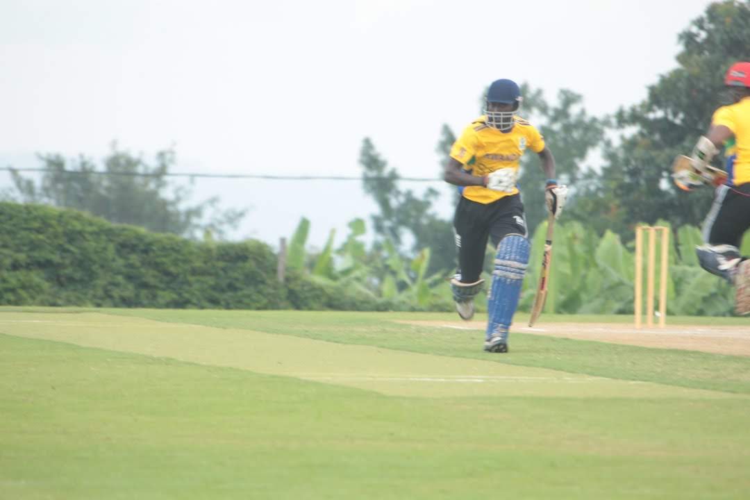 A batter running between the wickets on a cricket ground